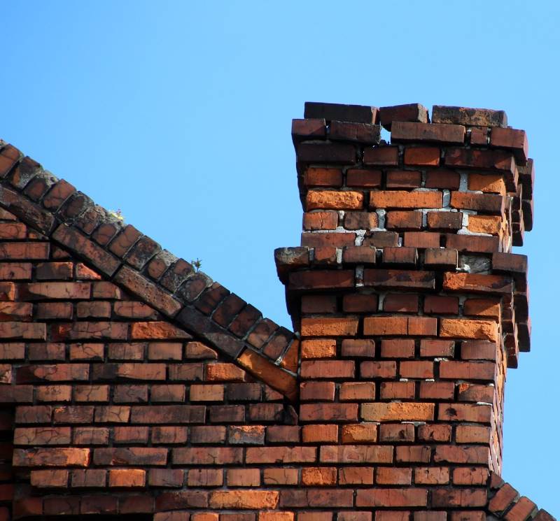 Damaged chimney on an Sutton home showing cracks and missing mortar